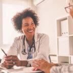 physician smiling and speaking to practice staff member