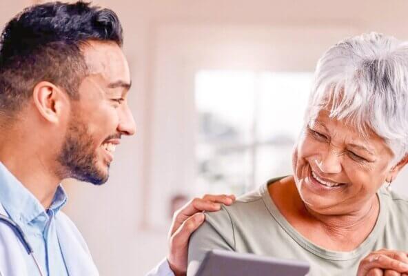 Physician smiling and speaking with patient about patient satisfaction scores