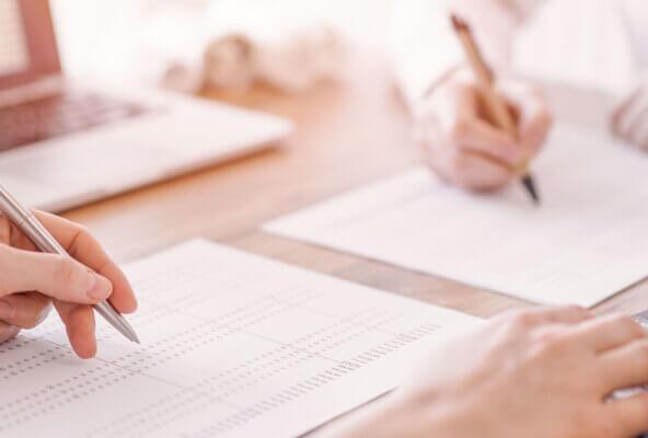 a left white hand holding a silver pen to show how handwritten-appearing signatures can enhance direct mail marketing