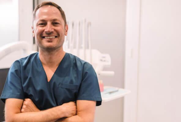 Smiling dentist poses for photo for his dental social media