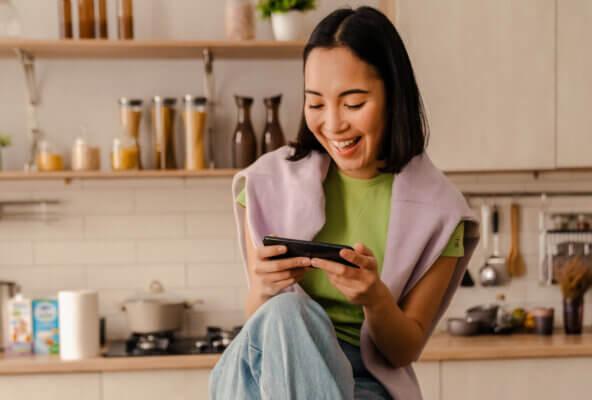 Smiling person looks at phone making a Google appointment with a healthcare provider