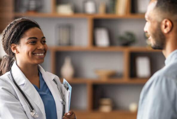 Physician smiles and greets a patient for an appointment after digital patient engagement