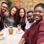 Multicultural group smiling while sitting at a table