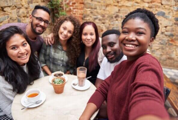 Multicultural group smiling while sitting at a table