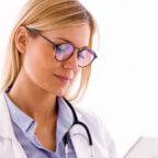 Physician reads on tablet about denial management strategies for electronic insurance claims submission