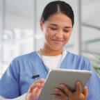 Nurse smiles while working with eRx software on tablet