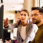 Medical practice staff members looking at computer screen discussing Google ads for medical practice
