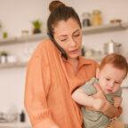 Mom holding toddler son is on the phone as one of the healthcare communication channels