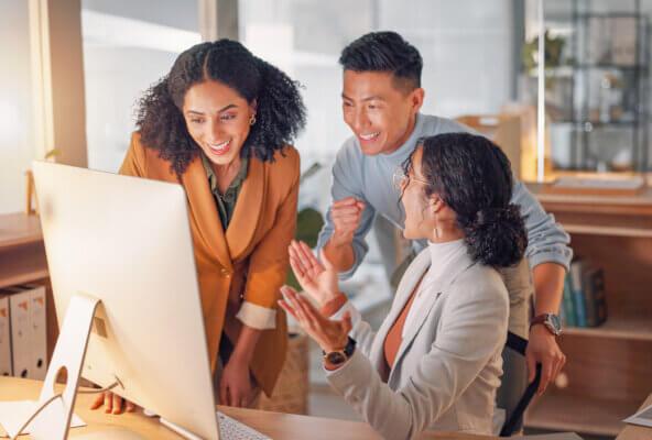 3 colleagues look at computer and celebrate as they get new medical billing business