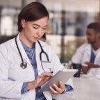 Physician looks at data on tablet as part of healthcare remote patient monitoring