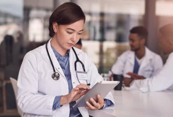 Physician looks at data on tablet as part of healthcare remote patient monitoring